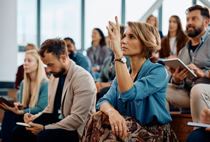woman in classroom with hand raised