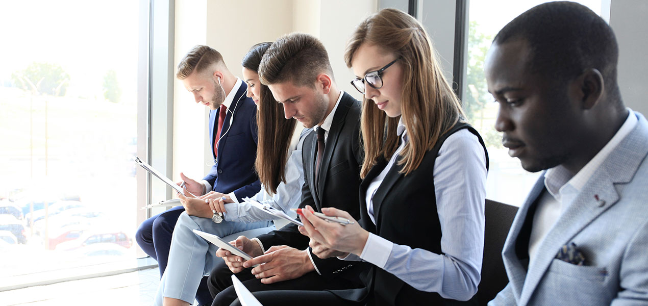 People sitting in a row looking at their phones